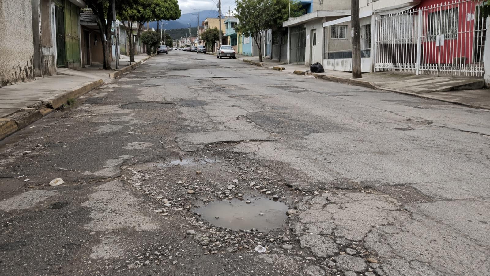 Vía con baches y agrietamientos pendiente de mantenimiento.
